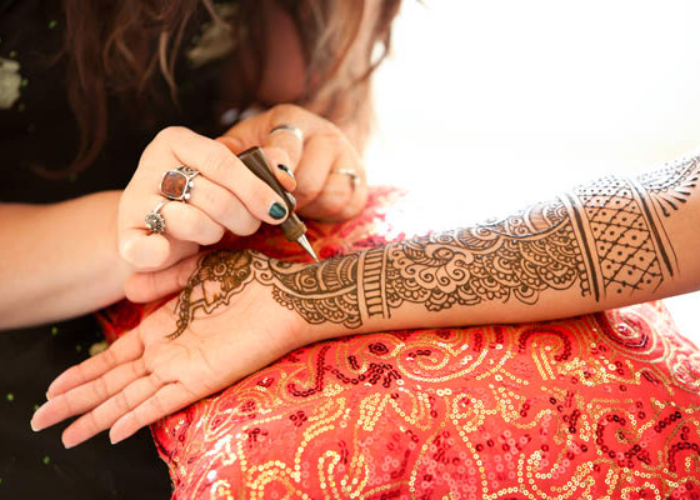 Detailed henna design being applied by hand